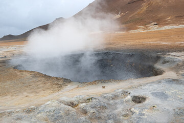bubbeling mud hole at the geothermal area of Hverir in Iceland on a cloudy summer day