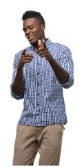 Young african american man wearing blue shirt pointing fingers to camera with happy and funny face. Good energy and vibes. © Krakenimages.com
