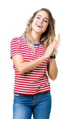 Beautiful young blonde woman over isolated background Clapping and applauding happy and joyful, smiling proud hands together