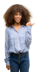 African american woman wearing a stripes shirt pointing with hand and finger up with happy face smiling