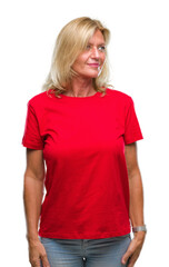 Fototapeta premium Middle age blonde woman over isolated background looking away to side with smile on face, natural expression. Laughing confident.