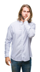 Young handsome man with long hair over isolated background thinking looking tired and bored with depression problems with crossed arms.