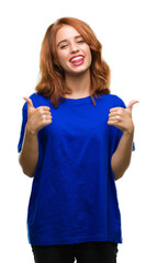 Young beautiful woman over isolated background success sign doing positive gesture with hand, thumbs up smiling and happy. Looking at the camera with cheerful expression, winner gesture.