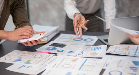 Collaborative Business Team Working on Financial Reports and Data Analysis in a Modern Office Setting