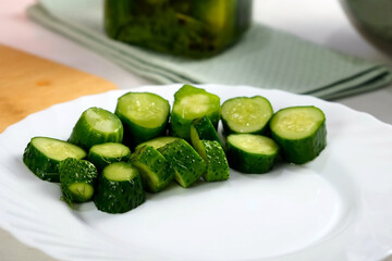 cucumbers pickles on white plate serving dish on kitchen at home, hands close-up. Cuisine, culinary, prepare cook dish, domestic food, recipe, fresh organic ingredients products concept.