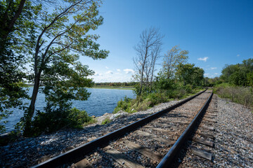Obraz premium Railroad track in perspective at the water's edge in Vermont