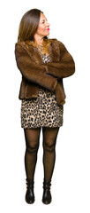 Beautiful middle age elegant woman wearing mink coat smiling looking to the side with arms crossed...