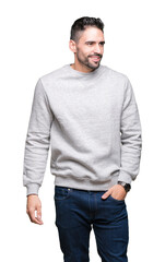 Young handsome man wearing sweatshirt over isolated background looking away to side with smile on face, natural expression. Laughing confident.