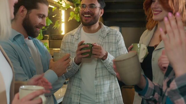 Happy multiracial group friends team mates freelance co-workers students colleagues joyful business men women diverse girls guys dancing male female buddies drink coffee dance laugh office break party