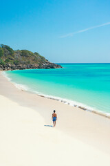 Seascape views with alone man walking at the white sand beaches  and clear water turquoise color. summer background and summer holiday concept.