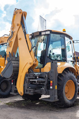 Yellow excavator at the back. Construction equipment.