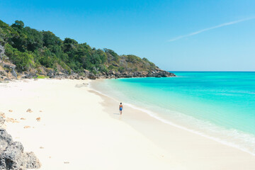 Young asian man walks on the beach in the summer alone on her vacation. summer background and summer holiday concept.