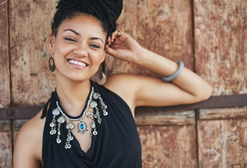 Fototapeta premium Outdoor, fashion and smile of woman, necklace and confident with boho style, creative and trendy. Portrait, city and person with unique jewellery, relax and comfortable with clothes, dress or Jamaica