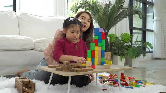 A young autistic child plays with their mother at home, engaged in a joyful and focused activity, surrounded by warmth and love.