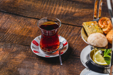 Freshly brewed black Turkish tea with cookies on wooden table