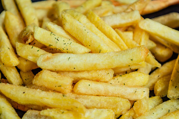 Close-up view of crispy French fries, or potato chips, on a black background