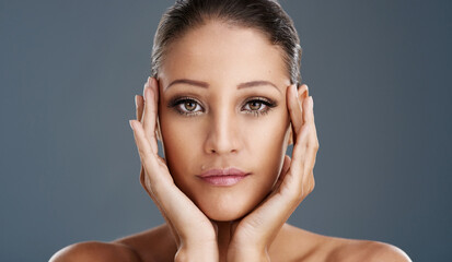 Woman, portrait and makeup with mascara for skincare, cosmetics or beauty on a gray studio background. Closeup, female person or young model with facial for hygiene, cosmetology or dermatology at spa