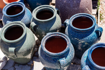 Ceramic pots for wine and beer on the street in the village. Handcrafted glazed vases in sunlight