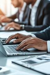 Fototapeta premium A man is typing on a laptop in front of a white desk