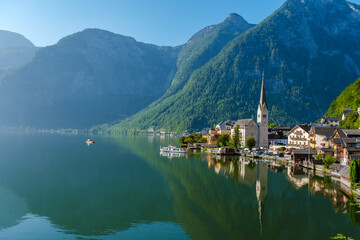 Serene morning in Hallstatt, Austria, with reflections of mountains on the tranquil lake