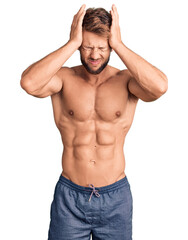 Young caucasian man standing shirtless suffering from headache desperate and stressed because pain and migraine. hands on head.