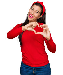 Young hispanic woman wearing casual clothes smiling in love doing heart symbol shape with hands. romantic concept.