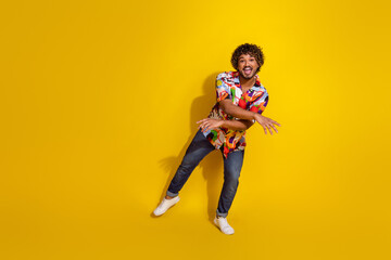 Full size photo of nice young man have fun dancing wear shirt isolated on yellow color background
