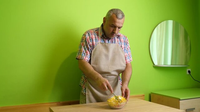 Salad of crab sticks, corn and eggs is seasoned with mayonnaise and mixed.