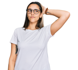 Young hispanic woman wearing casual white t shirt confuse and wondering about question. uncertain with doubt, thinking with hand on head. pensive concept.