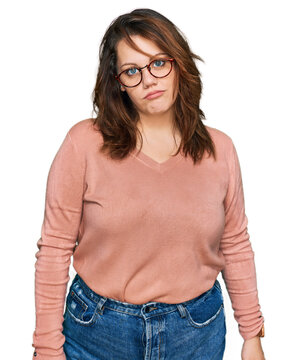 Young plus size woman wearing casual clothes and glasses looking sleepy and tired, exhausted for fatigue and hangover, lazy eyes in the morning.