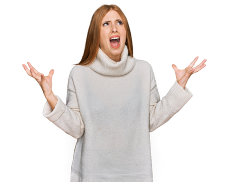 Young irish woman wearing casual winter sweater crazy and mad shouting and yelling with aggressive expression and arms raised. frustration concept.