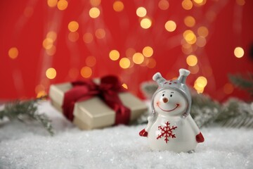Cute decorative snowman on artificial snow, space for text