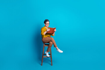 Full length photo of confident attractive lady dressed shirt glasses sitting stool read novel emtpy...