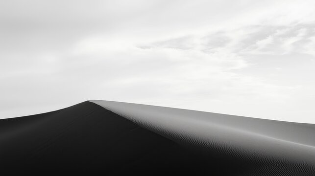Fototapeta Black and white sand dune rising against a vast, empty sky, gentle curves and expansive horizon evoke isolation and serene simplicity in minimalist landscape