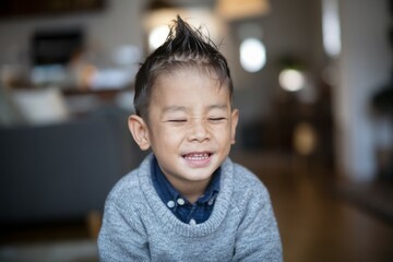 Happy boy smiling. Young boy with spiky hair smiling, showing happiness and joy.