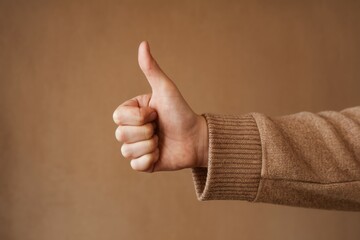 Thumbs up gesture. Hand showing thumbs up gesture, signifying approval, agreement, and positivity.
