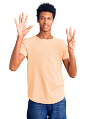 Young african american man wearing casual clothes showing and pointing up with fingers number eight while smiling confident and happy.