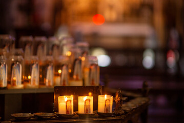 Warm glow of prayer candles illuminating sacred chapel ambience