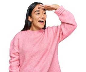 Young asian woman wearing casual winter sweater very happy and smiling looking far away with hand over head. searching concept.