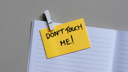Don't Touch ME! message concept written post it on notebook.