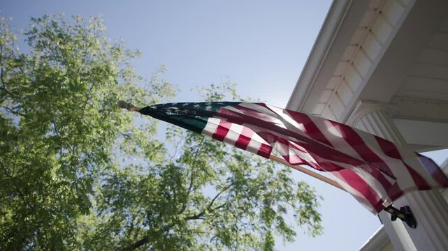 Detailed slow motion view and abstract background of the red, white, and blue American flag as it sways in the wind on a rural conservative porch on a warm, summer day in Lancaster, Ohio