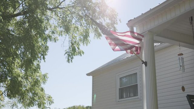 Detailed slow motion view and abstract background of the red, white, and blue American flag as it sways in the wind on a rural conservative porch on a warm, summer day in Lancaster, Ohio