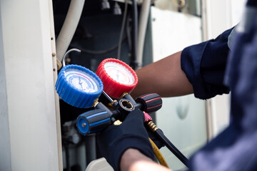 Air conditioning, HVAC service technician using gauges to check refrigerant and add refrigerant,Air Conditioning Repair, repairman on the floor fixing air conditioning system.