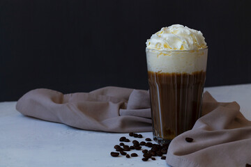 Cold frappe coffee with whipped cream. coffee cocktail in American glass with whipped cream on dark background. Alcoholic or non-alcoholic cocktail with liqueur, whiskey, white cream. copy space.