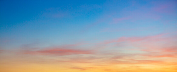 Obraz premium Colorful clouds and sky. Dusk and sunset. Evening clouds with orange, yellow, pink and red sunlight and amazing storm clouds in the dusk sky. 