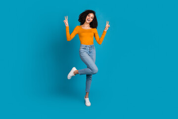Full body photo of attractive young woman show v-sign dressed stylish yellow clothes isolated on blue color background