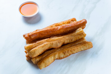 Youtiao or Yu Char Kway or cakwe is a long golden-brown deep-fried strip of wheat flour dough of Chinese origin. Perfect for recipe, article, catalogue, commercial, or any cooking content.