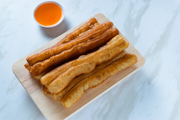 Youtiao or Yu Char Kway or cakwe is a long golden-brown deep-fried strip of wheat flour dough of Chinese origin. Perfect for recipe, article, catalogue, commercial, or any cooking content.