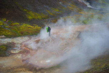 Fototapeta premium Solo hiker in geothermal area with dense steam in Iceland