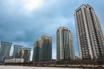 Obraz premium Winter embankment in the park of Kyiv. River Mall Park. Near the new buildings of multi-storey buildings.